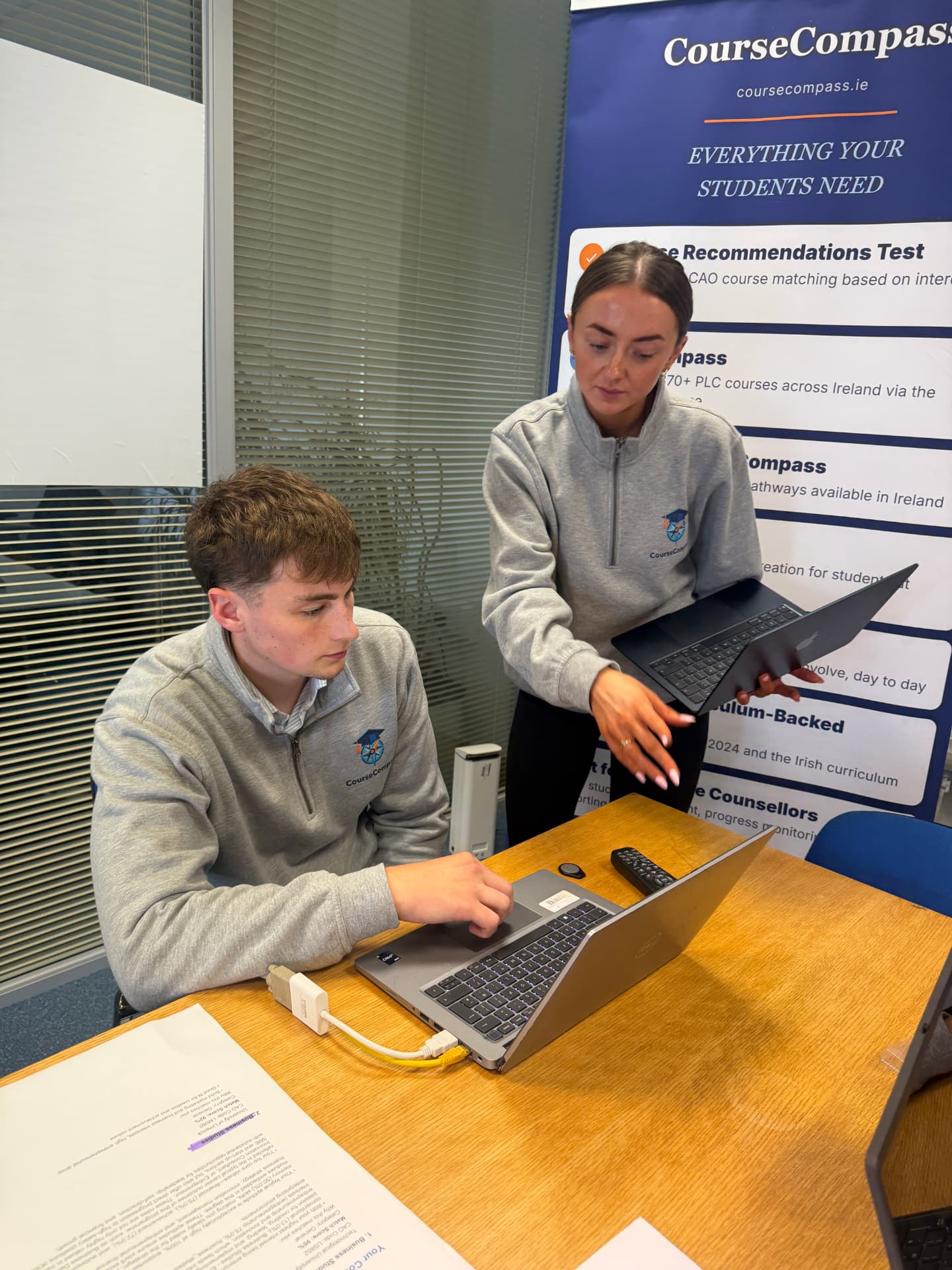 Two CourseCompass team members reviewing a printed student career assessment report